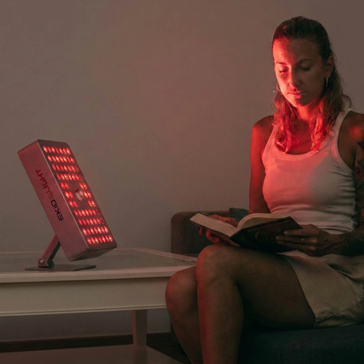 Terapia de luz Roja con la lámpara Bio Regen 7 de ekio light mientras chica lee un libro tranquilamente 