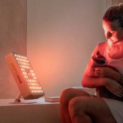 lámpara de luz Roja Bio Regen 7 de ekio light dando luz terapeútica a chica y gato