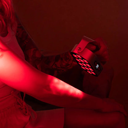 Mujer utilizando la lámpara de luz roja CORE de EKIO Light sobre el brazo