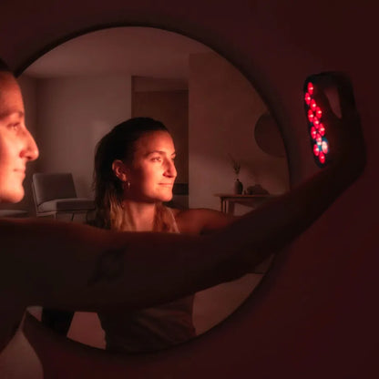 Mujer utilizando la lámpara de luz roja CORE de EKIO Light
